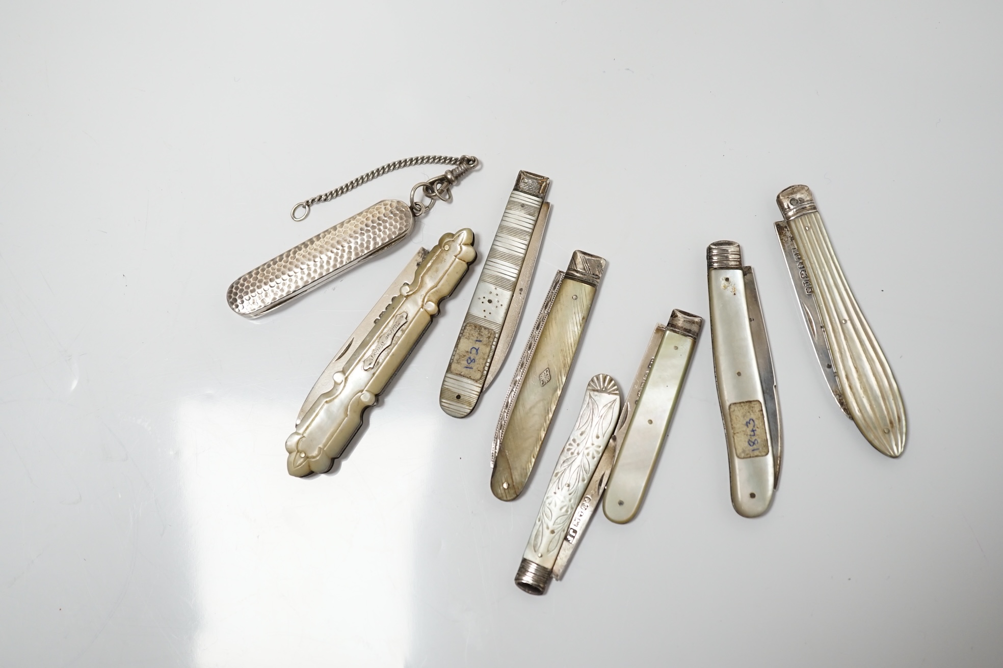 A collection of six assorted Victorian mother of pearl and silver bladed pocket fruit knives, a similar white metal fruit knife and a silver pin case. Condition - poor to fair